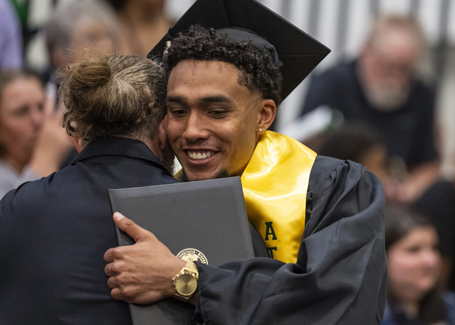 Student hugging mentor at commencement
